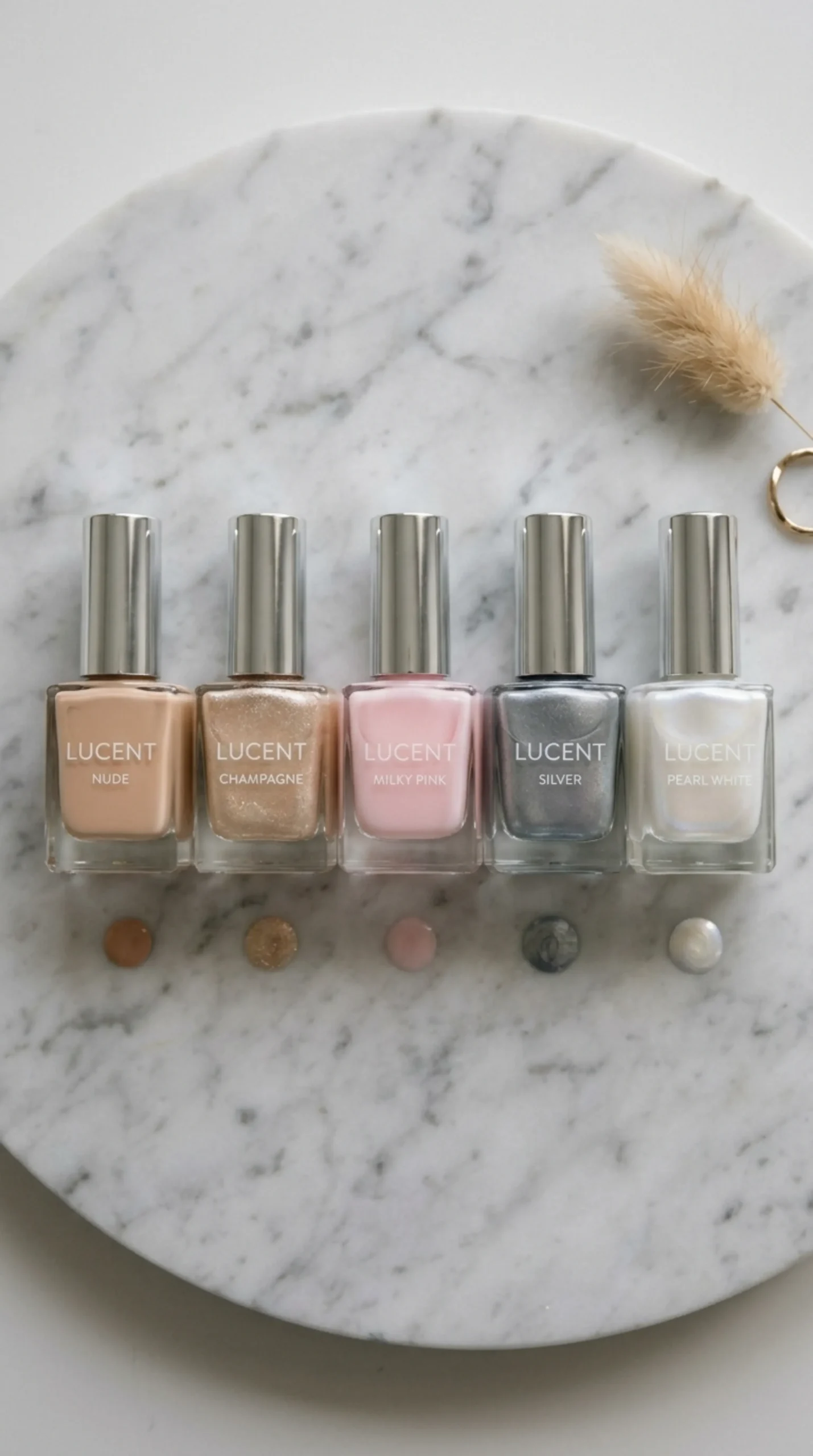 Flat lay of nude, champagne and pearl nail polish bottles on marble