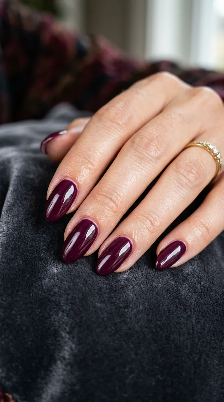 Glossy deep plum jewel-tone almond nails for a fall wedding guest