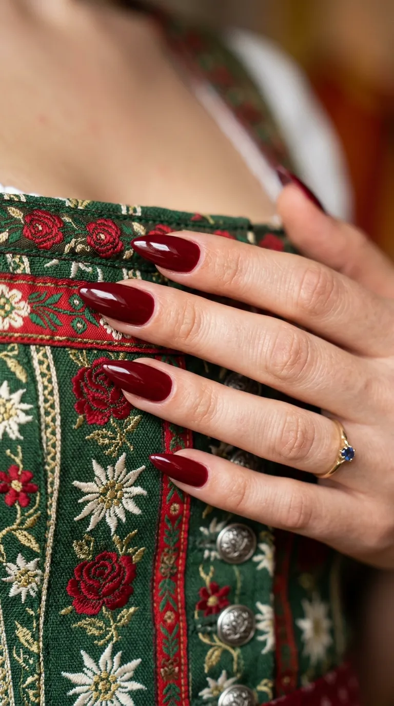 Oktoberfest nails in deep red inspired by a traditional dirndl bodice