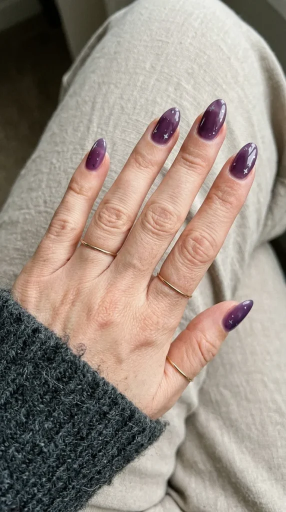 Deep purple jelly almond nails with small silver star dots