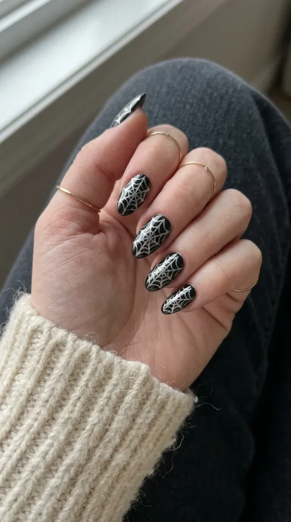 Black almond nails with a silver chrome spiderweb