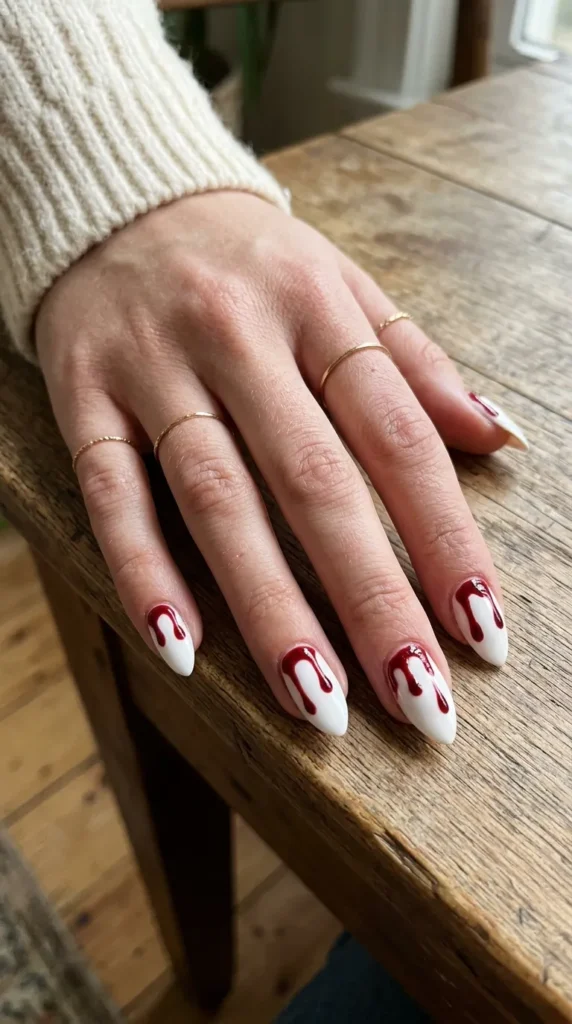 White almond nails with red blood drips from the tips
