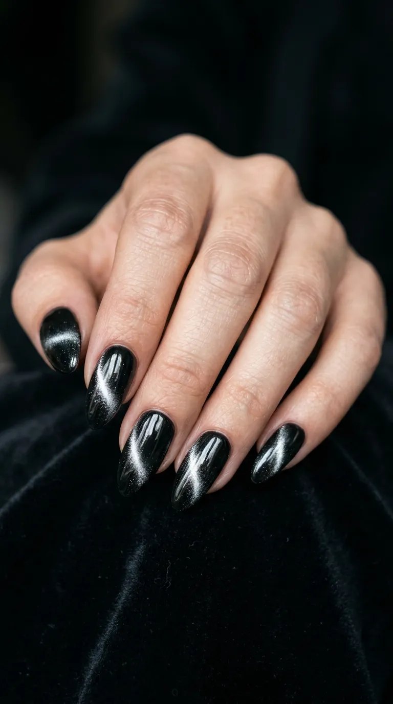 Black cat-eye nails with a shimmering magnetic line on almond nails