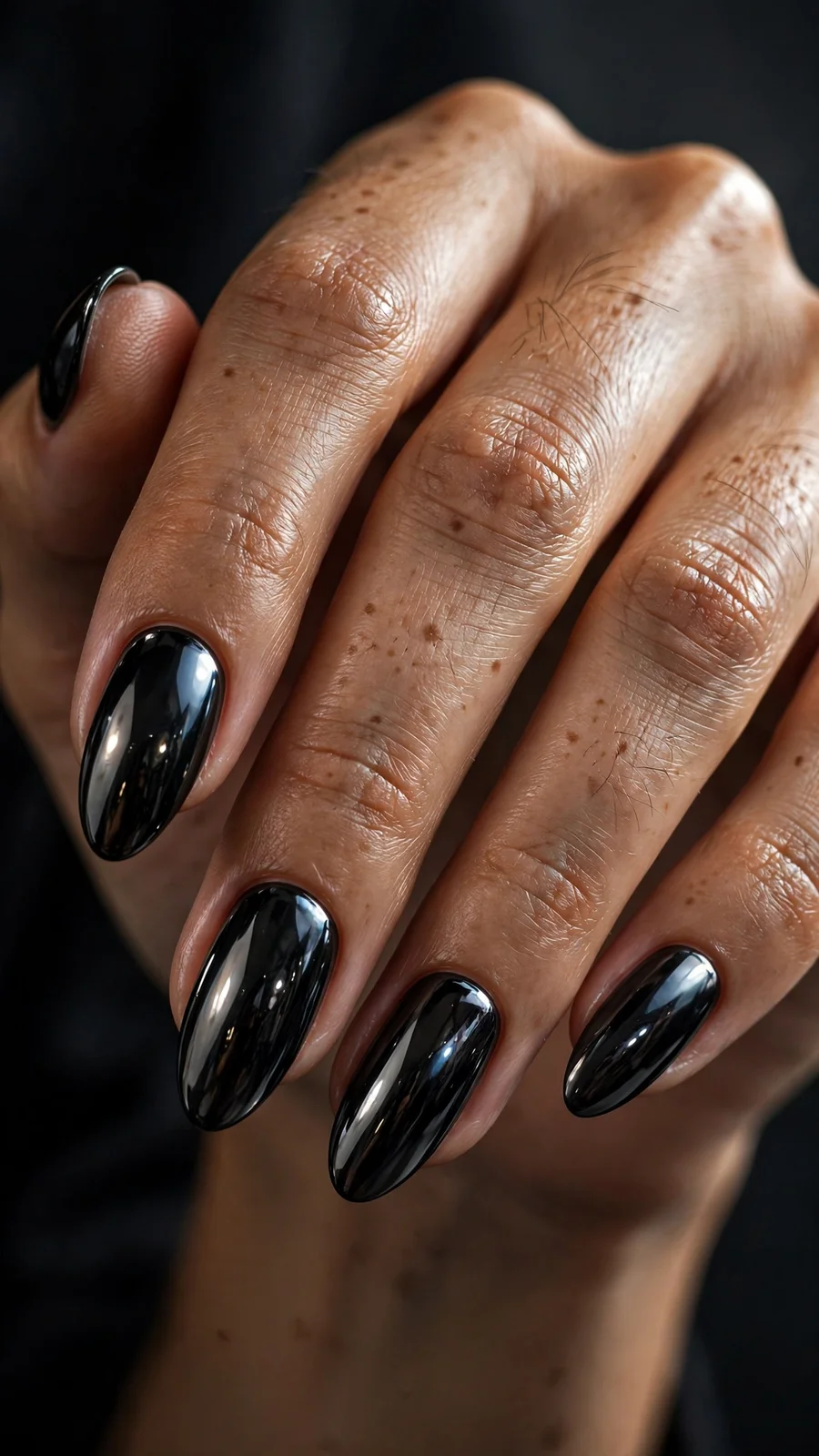 Black chrome nails on almond-shaped nails