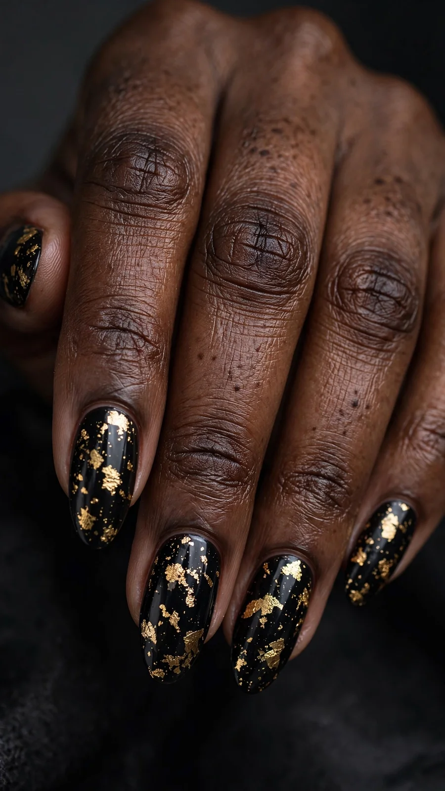 Black nails with gold foil flakes