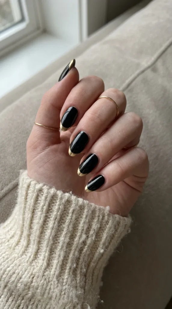 Black nails with thin gold chrome French tips