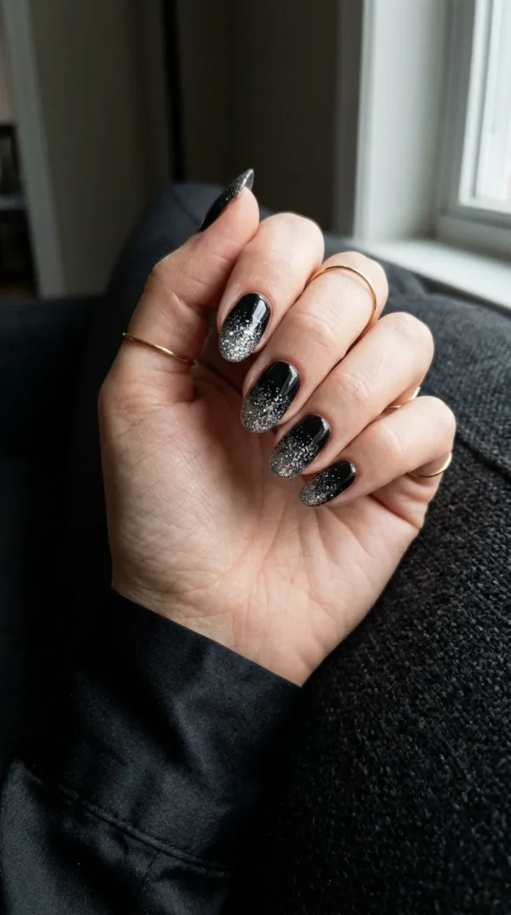 Black nails with silver glitter fading upward from the tips