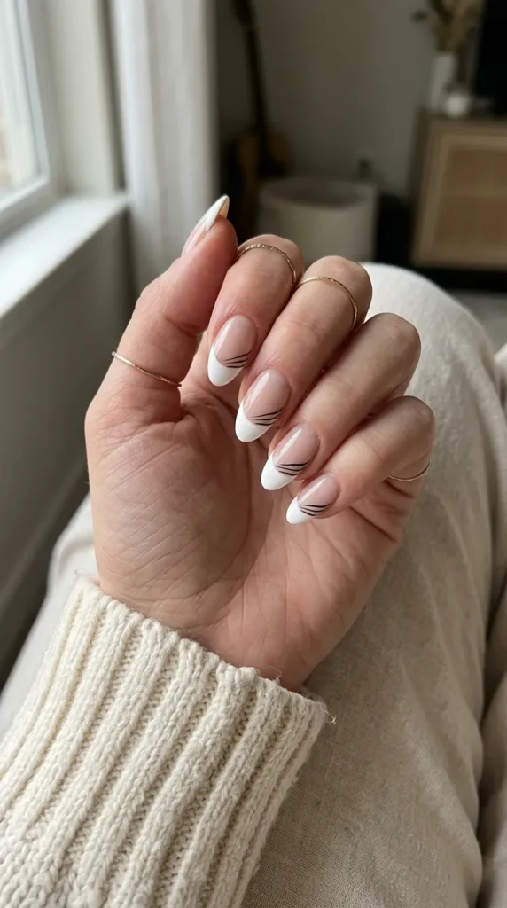 White French tip nails with three thin black whisker lines