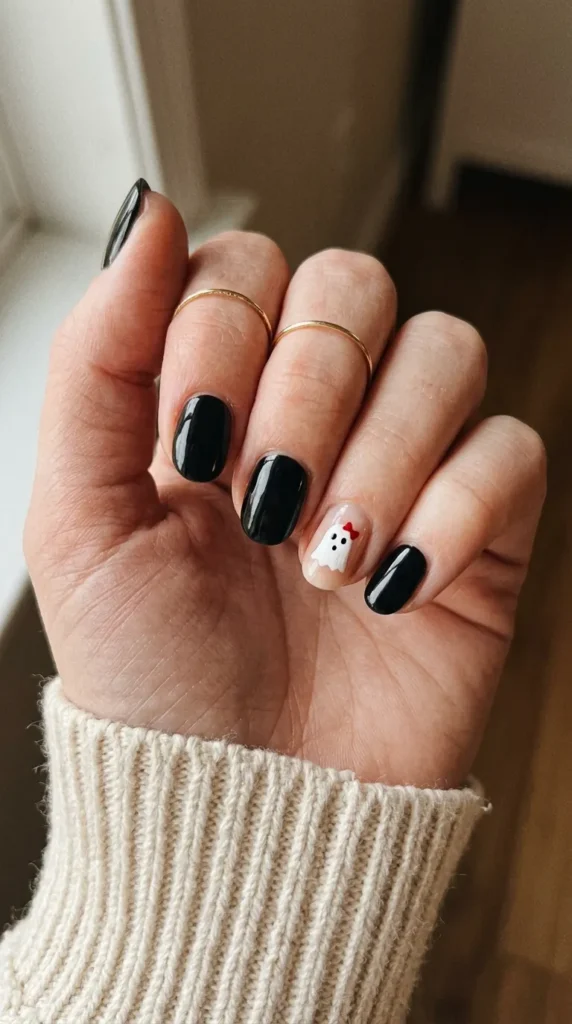 hello kitty halloween nails: black nails with a white ghost-sheet kitty wearing a red bow