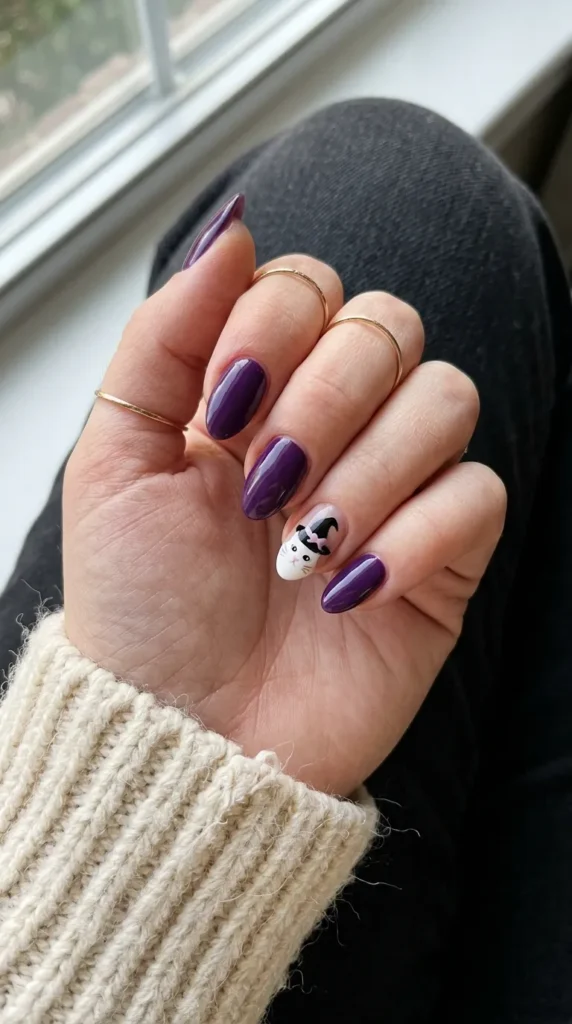 Purple nail with a white kitty face under a small black witch hat