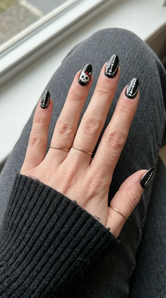 Black nails with white skeleton lines and a small kitty skull face