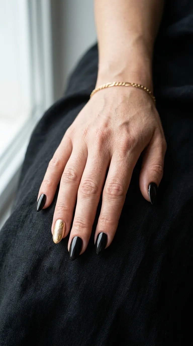 Black homecoming manicure with one gold foil accent nail