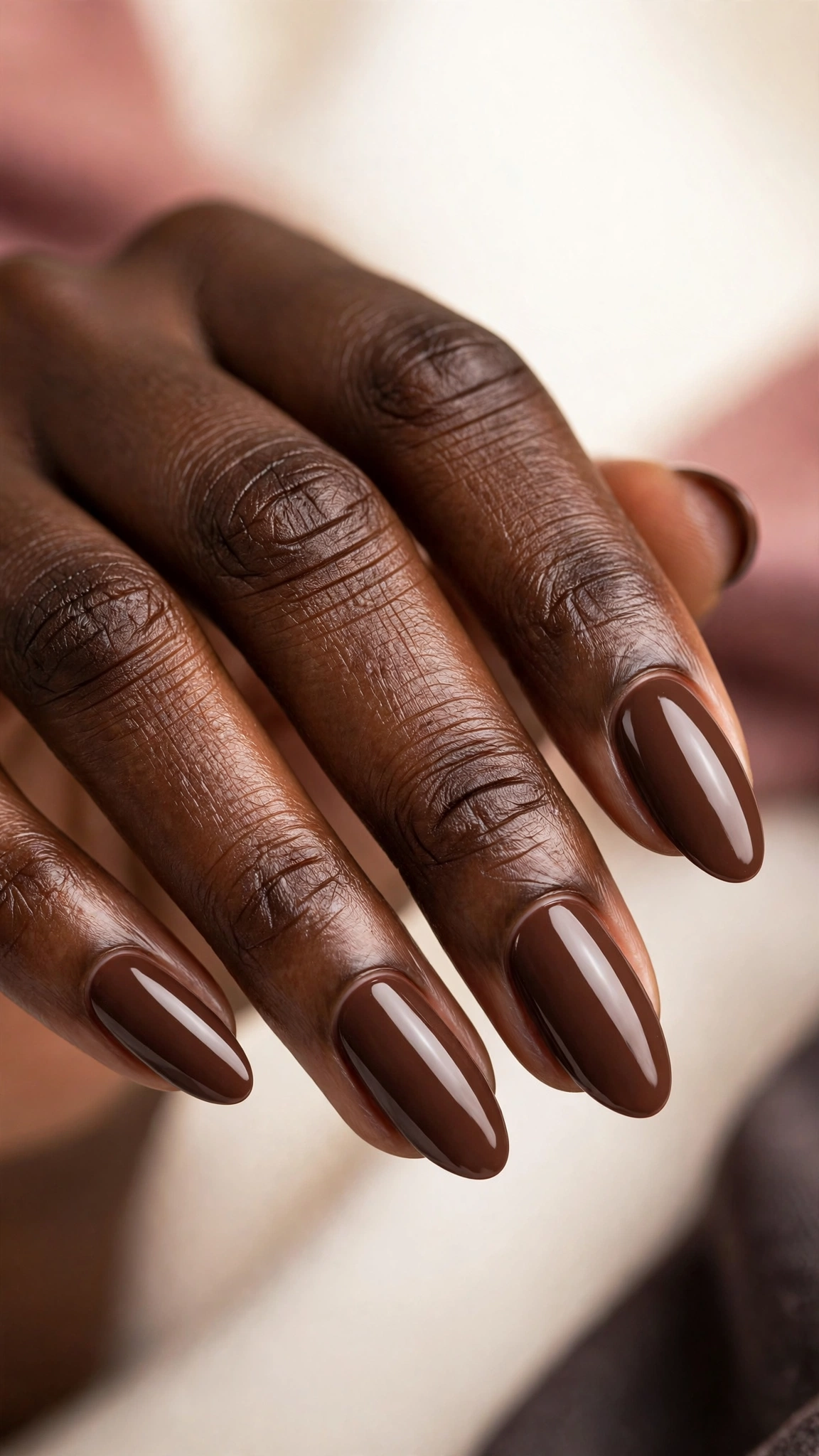 Rich chocolate brown creme nail polish, glossy, on dark skin hands