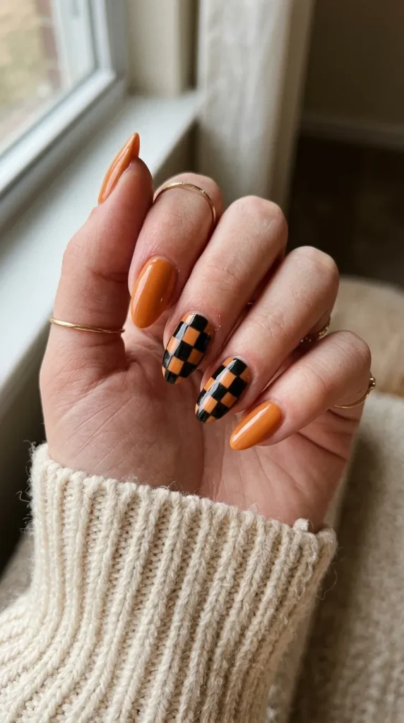 Orange nails with black and orange checkerboard accent nails