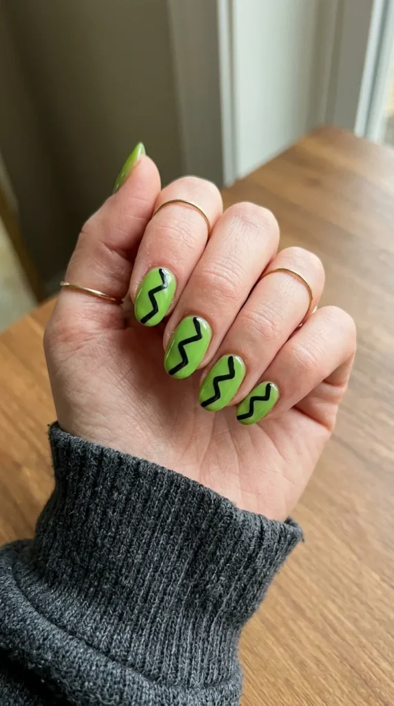 Lime green nails with a black zigzag stripe across each nail