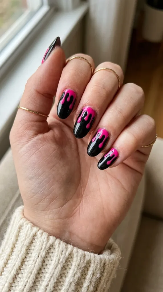 Glossy black nails with hot pink drip running from the cuticle