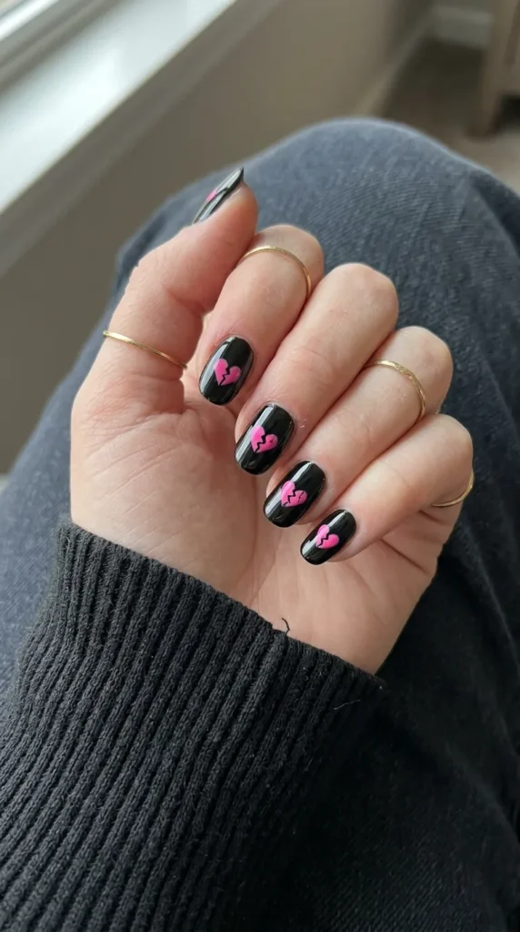 Black nails with small pink cracked heart details
