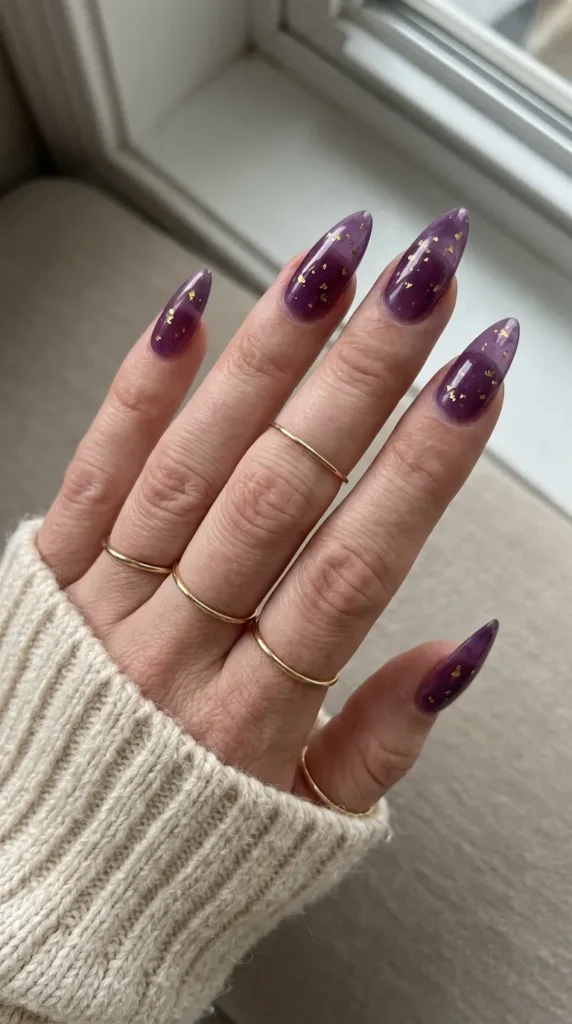 Purple jelly stiletto nails with scattered gold flecks