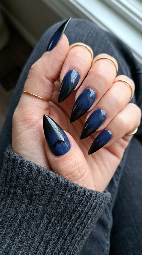Navy to black gradient stiletto nail with a bat silhouette
