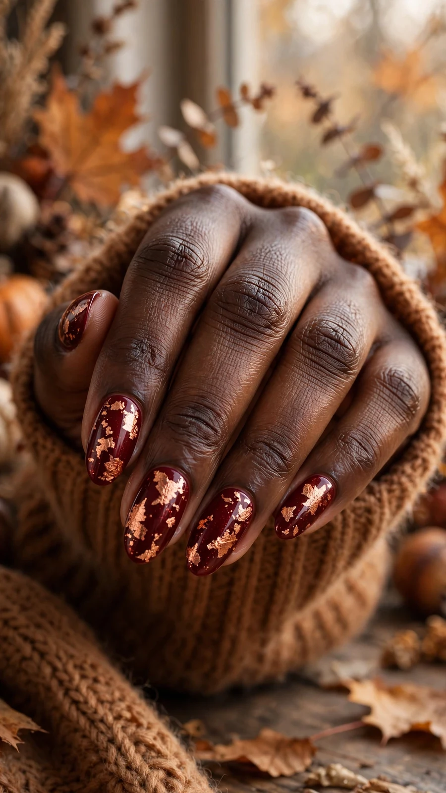 Thanksgiving nail designs: deep red nails with copper leaf accents