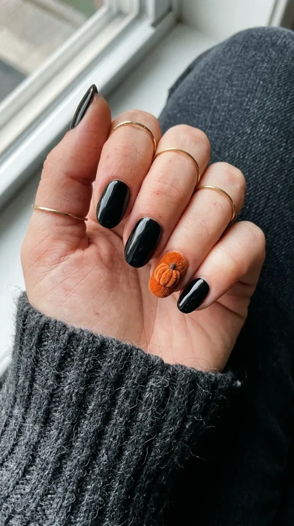 Orange velvet-textured pumpkin accent nails on a black base