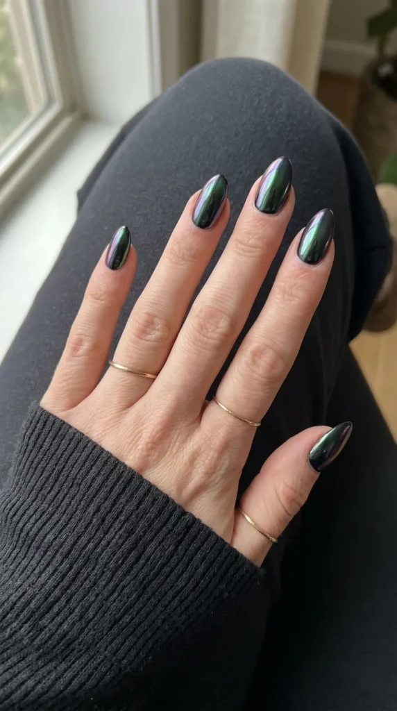 Black nails with a green purple and blue oil-slick chrome finish